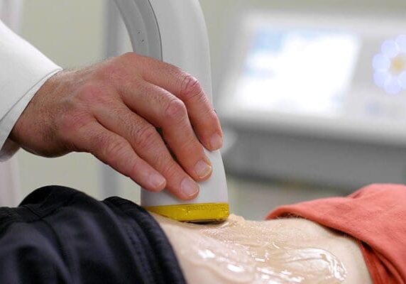 Doctor applying softwave therapy on a patients back